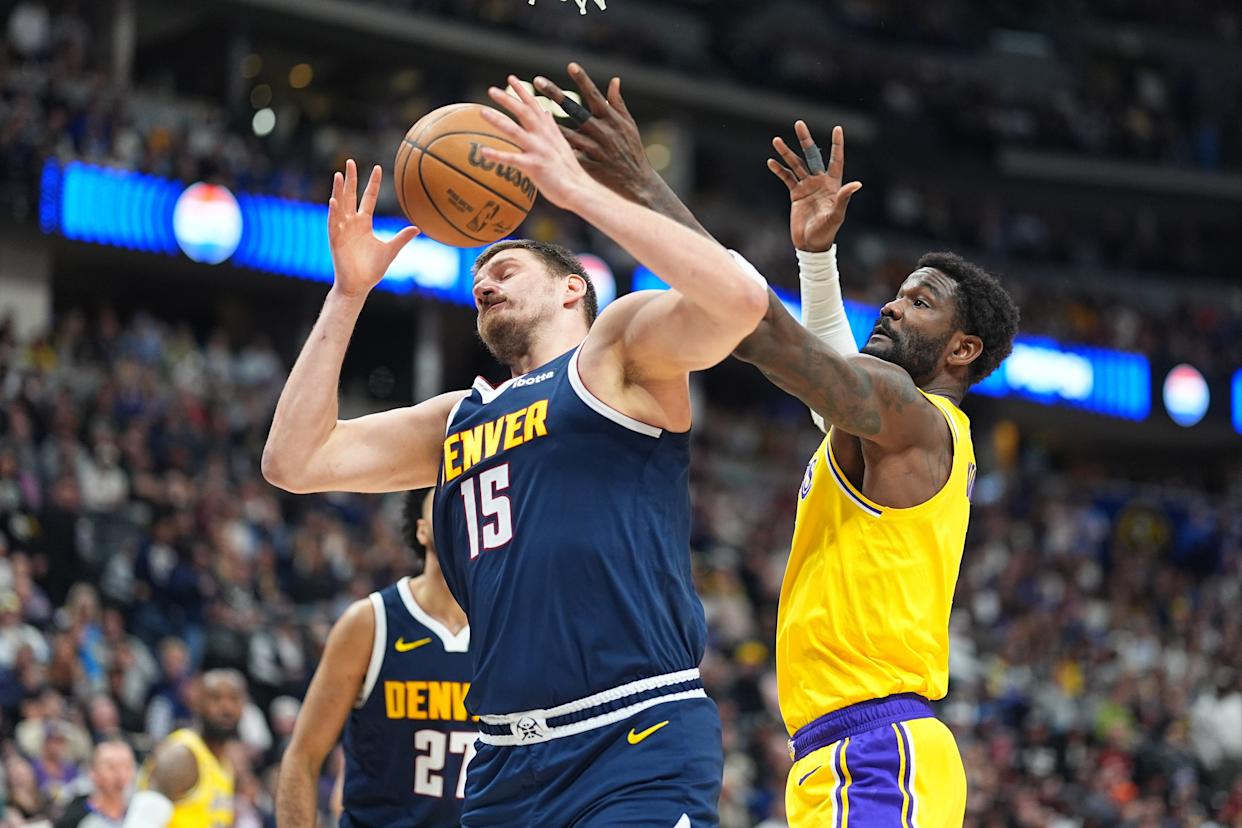 Denver Nuggets center Nikola Joki¿, left, fights for control of a rebound with Los Angeles Lakers center Deandre Ayton in the first half of an NBA basketball game Thursday, March...