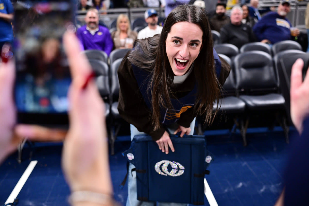 Indiana Fever guard Caitlin Clark reacts to her logo on a court chair Marc Lebryk-Imagn Images
