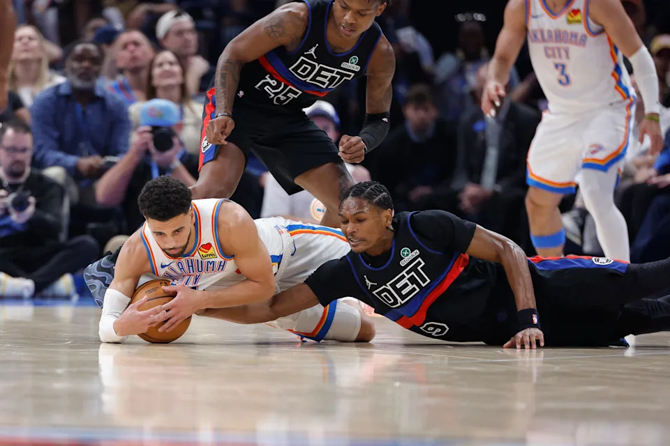 Mar 30, 2026; Oklahoma City, Oklahoma, USA; Oklahoma City Thunder guard Ajay Mitchell (25) and Detroit Pistons guard Ausar Thompson (9) fight for a loose ball during the first half at Paycom Center. Mandatory Credit: Alonzo Adams-Imagn Images
