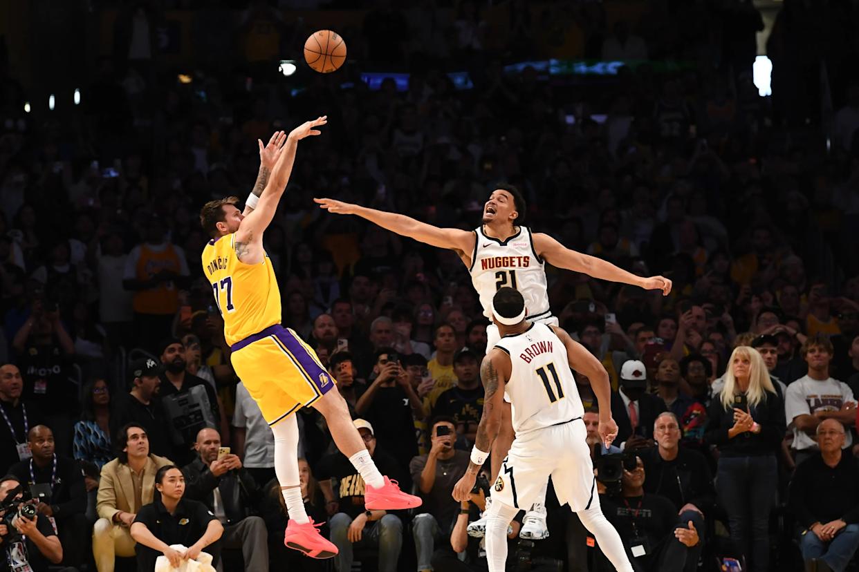 Luka Doncic (Los Angeles Lakers) shoots a game-winning shot against Nikola Jokic (Denver Nuggets) and Christian Braun (Denver Nuggets).