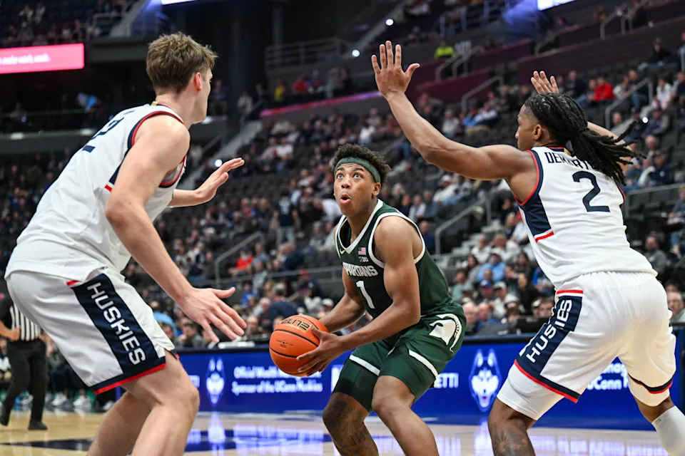 Oct 28, 2025; Hartford, CT, USA; Michigan State Spartans guard Jeremy Fears Jr. (1) looks to shoot the ball defended by Connecticut Huskies center Eric Reibe (12) and Connecticut Huskies guard Silas Demary Jr. (2) during the second half at PeoplesBank Arena. Mandatory Credit: Mark Smith-Imagn Images
