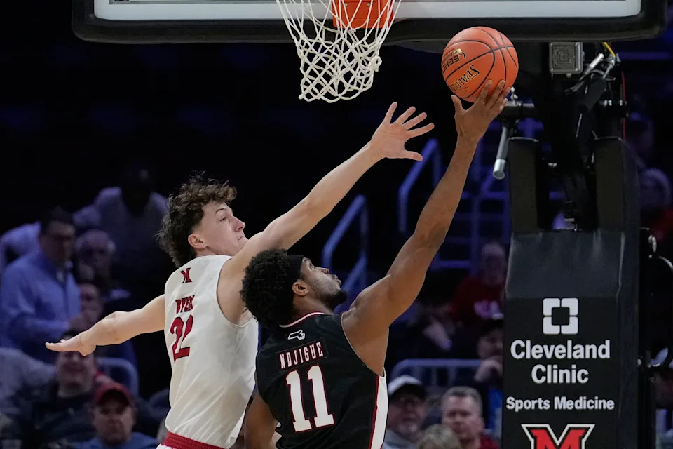 Massachusetts' Jayden Ndjigue (11) shoots as Miami forward Brant Byers (22) defends in the first half of an NCAA college basketball game in the quarterfinals of the Mid-American Conference tournament, Thursday, March 12, 2026, in Cleveland. (AP Photo/Sue Ogrocki)