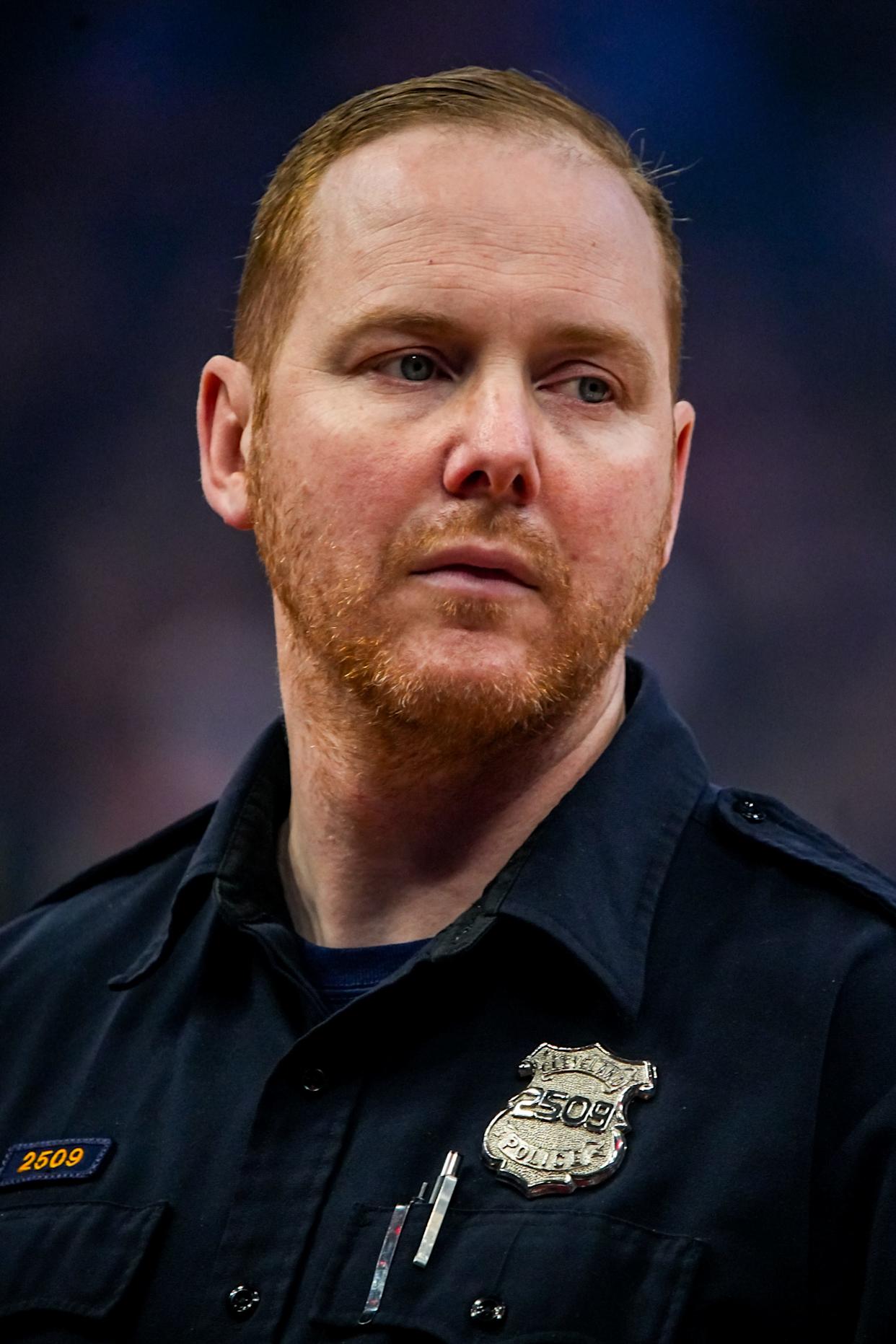 Cleveland police officer Chris Porter scans the crowd as he works security during a timeout at a Cavaliers game at Rocket Arena.
