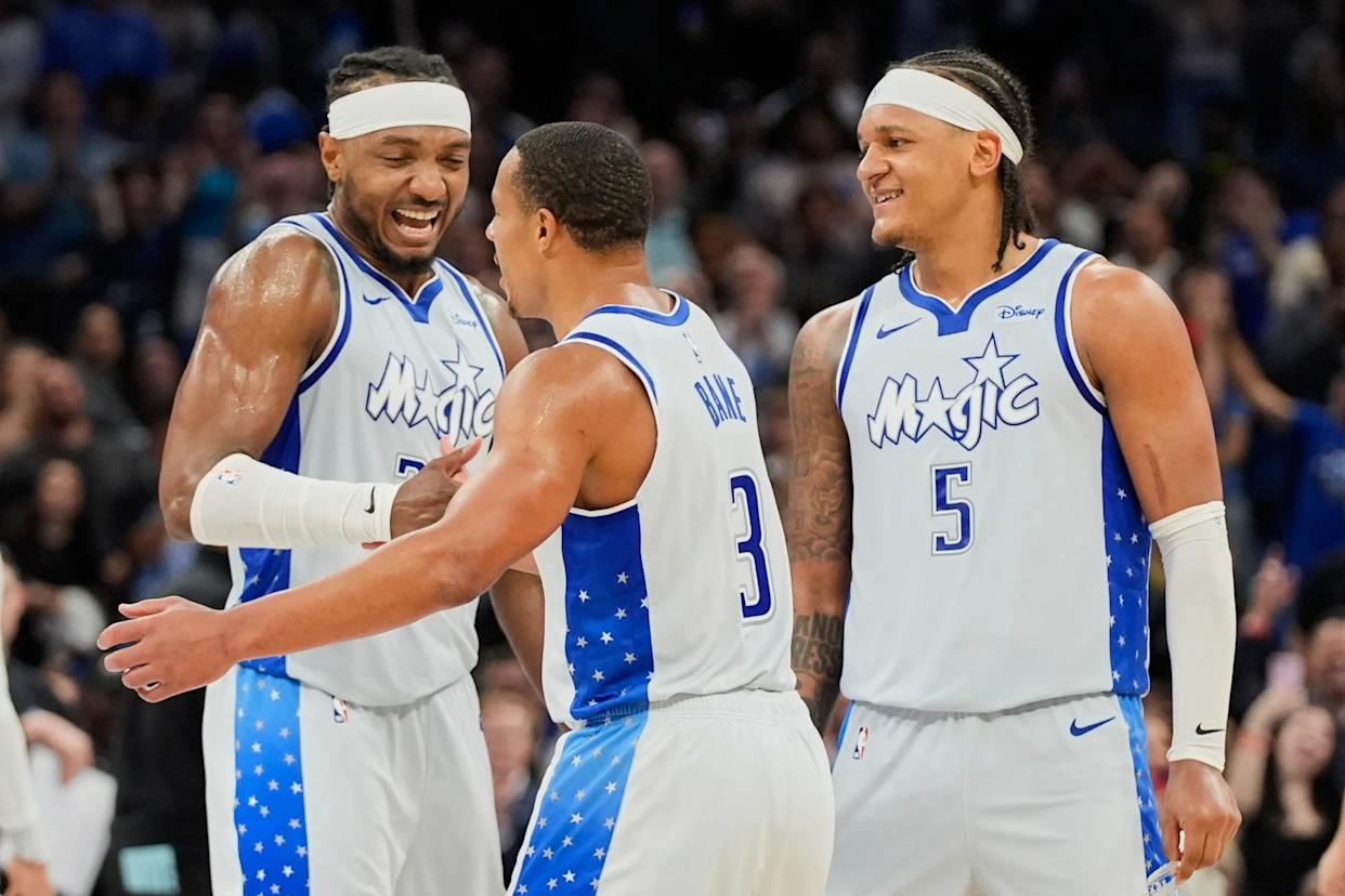 An image collage containing 1 images, Image 1 shows Orlando Magic center Wendell Carter Jr., left, and forward Paolo Banchero (5) celebrate with guard Desmond Bane (3) after Bane made a 3-point shot