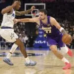 Los Angeles Lakers guard Luka Doncic (77) moves the ball past Orlando Magic forward Jamal Cain (8) in the second quarter at Kia Center.