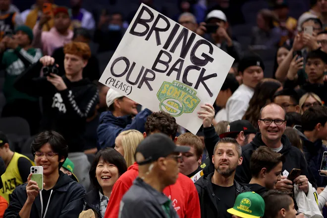 SEATTLE, WASHINGTON - OCTOBER 10: A Seattle Sonics fan holds a sign before the Rain City Showcase in a preseason NBA game between the LA Clippers and the Utah Jazz at Climate Pledge Arena on October 10, 2023 in Seattle, Washington. (Photo by Steph Chambers/Getty Images)