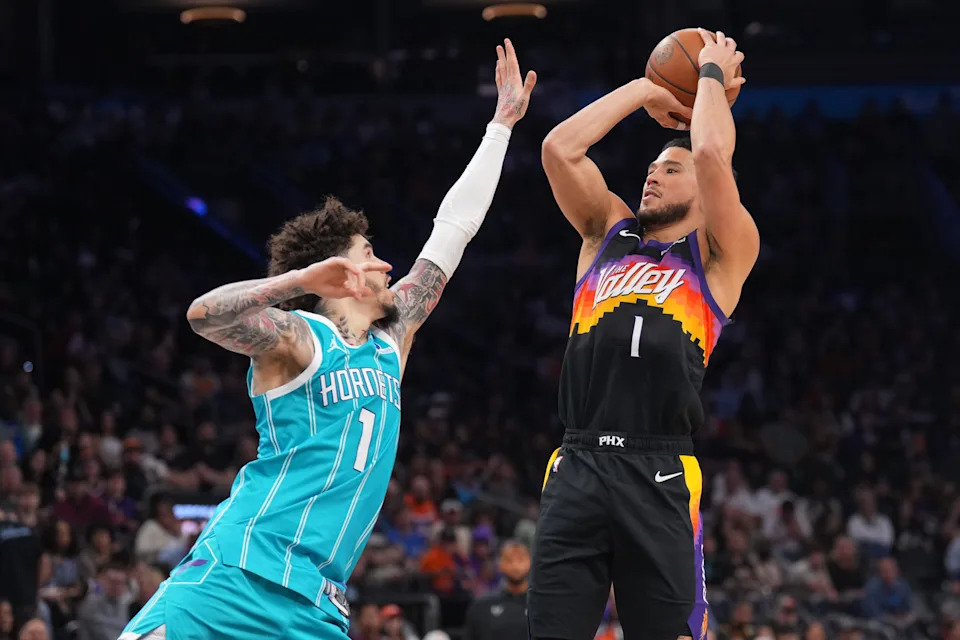 Phoenix Suns guard Devin Booker (1) shoots over Charlotte Hornets guard LaMelo Ball (1) during the second half at Mortgage Matchup Center on March 8, 2026.