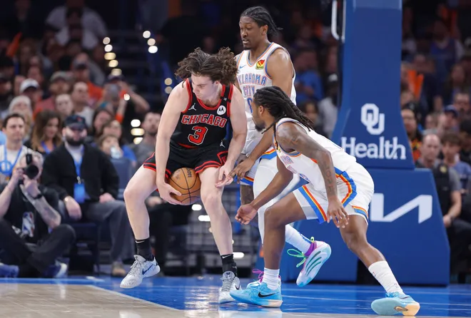 Mar 31, 2025; Oklahoma City, Oklahoma, USA; Chicago Bulls guard Josh Giddey (3) works to control the ball as Oklahoma City Thunder guard Cason Wallace (22) and forward Jalen Williams (8) defend the play during the second quarter at Paycom Center. Mandatory Credit: Alonzo Adams-Imagn Images