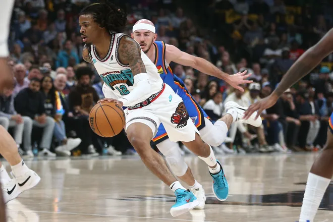 Apr 24, 2025; Memphis, Tennessee, USA; Memphis Grizzlies guard Ja Morant (12) drives to the basket as Oklahoma City Thunder guard Alex Caruso (9) defends during the second quarter during game three for the first round of the 2024 NBA Playoffs at FedExForum.
