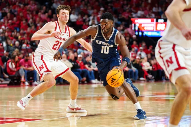 Dec 30, 2025; Lincoln, Nebraska, USA; New Hampshire Wildcats guard Comeh Emuobor (10) drives against Nebraska Cornhuskers forward Pryce Sandfort (21) during the second half at Pinnacle Bank Arena.