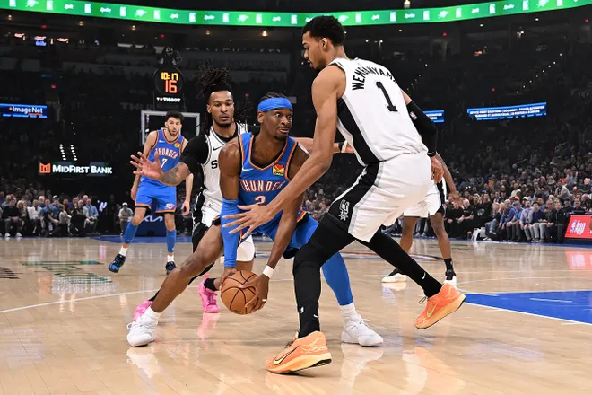 OKLAHOMA CITY, OKLAHOMA - JANUARY 13: Shai Gilgeous-Alexander #2 of the Oklahoma City Thunder handles the ball in front of Victor Wembanyama #1 of the San Antonio Spurs during the first half at Paycom Center on January 13, 2026 in Oklahoma City, Oklahoma. NOTE TO USER: User expressly acknowledges and agrees that, by downloading and or using this photograph, User is consenting to the terms and conditions of the Getty Images License Agreement. (Photo by Joshua Gateley/Getty Images)