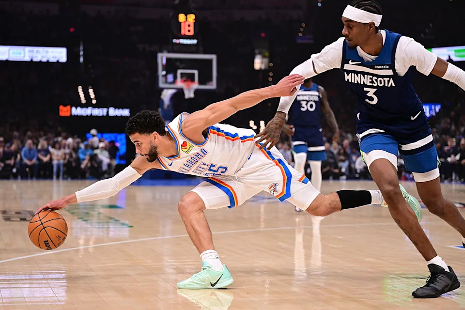 OKLAHOMA CITY, OKLAHOMA - MARCH 15: Ajay Mitchell #25 of the Oklahoma City Thunder reaches for the ball in front of Jaden McDaniels #3 of the Minnesota Timberwolves during the first half at Paycom Center on March 15, 2026 in Oklahoma City, Oklahoma. NOTE TO USER: User expressly acknowledges and agrees that, by downloading and or using this photograph, User is consenting to the terms and conditions of the Getty Images License Agreement. (Photo by Joshua Gateley/Getty Images)