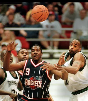 Minnesota Timberwolves Dean Garrett (R) knocks the ball out of Houston Rockets Steve Francis' hands as Wolves Kevin Garnet (far L) and Rockets Anthony Miller (2nd L) look on in the second quarter of their game 30 March 2000, at Target Center in Minneapolis, Minnesota. The Wolves won 122-90. AFP PHOTO Craig Lassig (Photo by CRAIG LASSIG / AFP) (Photo by CRAIG LASSIG/AFP via Getty Images)
