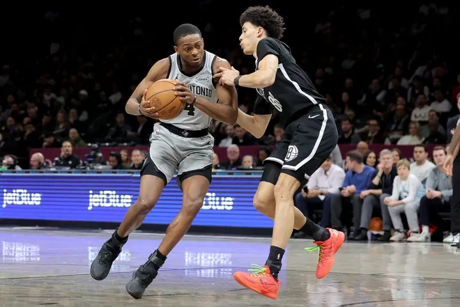 Feb 26, 2026; Brooklyn, New York, USA; San Antonio Spurs guard De'aaron Fox (4) drives to the basket against Brooklyn Nets guard Nolan Traore (88) during the first quarter at Barclays Center.