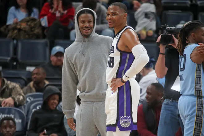 Feb 23, 2026; Memphis, Tennessee, USA; Memphis Grizzlies guard Ja Morant (left) and Sacramento Kings guard Russell Westbrook (18) talk during a timeout during the fourth quarter at FedExForum. Mandatory Credit: Petre Thomas-Imagn Images