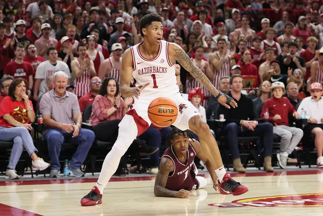 Feb 25, 2026; Fayetteville, Arkansas, USA; Arkansas Razorbacks guard Meleek Thomas (1) steals the ball from Texas A&M Aggies guard Josh Holoway (1) during the first half at Bud Walton Arena. Mandatory Credit: Nelson Chenault-Imagn Images