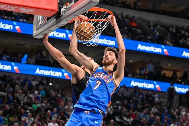 Mar 1, 2026; Dallas, Texas, USA; Oklahoma City Thunder center Chet Holmgren (7) dunks the ball past Dallas Mavericks forward Dwight Powell (7) during the second half at the American Airlines Center. Mandatory Credit: Jerome Miron-Imagn Images