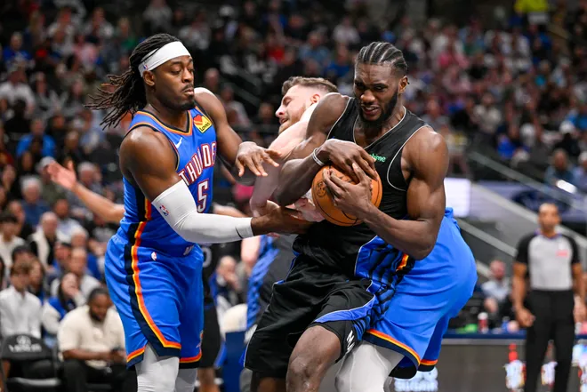 Mar 1, 2026; Dallas, Texas, USA; Dallas Mavericks center Moussa Cisse (30) grabs the ball away from Oklahoma City Thunder guard Luguentz Dort (5) and center Isaiah Hartenstein (55) during the second half at the American Airlines Center. Mandatory Credit: Jerome Miron-Imagn Images