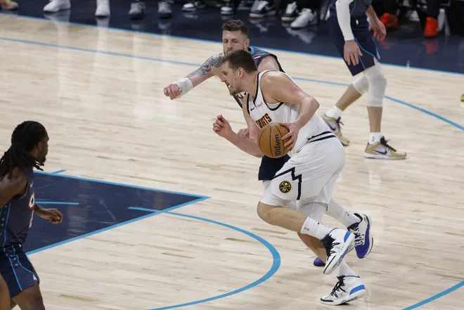 Feb 27, 2026; Oklahoma City, Oklahoma, USA; Denver Nuggets center Nikola Jokić (15) drives down the court past Oklahoma City Thunder center/forward Isaiah Hartenstein (55) during the fourth quarter at Paycom Center.