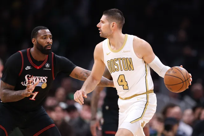 Mar 1, 2026; Boston, Massachusetts, USA; Boston Celtics center Nikola Vucevic (4) dribbles down the court defended by Philadelphia 76ers center Andre Drummond (1) during the first half at TD Garden. Mandatory Credit: Paul Rutherford-Imagn Images