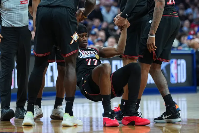 PHILADELPHIA, PENNSYLVANIA - MARCH 3: Vj Edgecombe #77 of the Philadelphia 76ers is helped up by teammates after an injury against the San Antonio Spurs in the second quarter at Xfinity Mobile Arena on March 3, 2026 in Philadelphia, Pennsylvania. The Spurs defeated the 76ers 131-91. NOTE TO USER: User expressly acknowledges and agrees that, by downloading and or using this photograph, User is consenting to the terms and conditions of the Getty Images License Agreement. (Photo by Mitchell Leff/Getty Images)