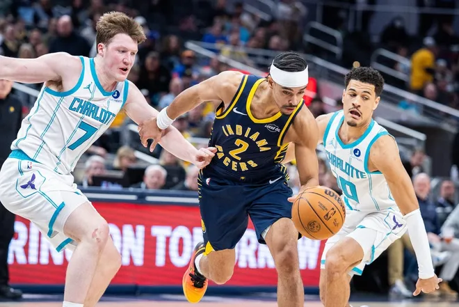 Feb 26, 2026; Indianapolis, Indiana, USA; Indiana Pacers guard Andrew Nembhard (2) dribbles the ball while Charlotte Hornets guard Kon Knueppel (7) defends in the second half at Gainbridge Fieldhouse.