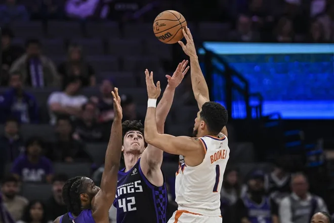 Mar 3, 2026; Sacramento, California, USA; Phoenix Suns guard Devin Booker (1) shoots over Sacramento Kings center Maxime Raynaud (42) during the fourth quarter at Golden 1 Center.