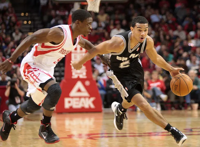 December 29, 2011; Houston, TX, USA; San Antonio Spurs guard Cory Joseph (5) brings the ball upcourt past Houston Rockets guard Jonny Flynn (9) in the fourth quarter at Toyota Center. Mandatory Credit: Troy Taormina-USA TODAY Sports