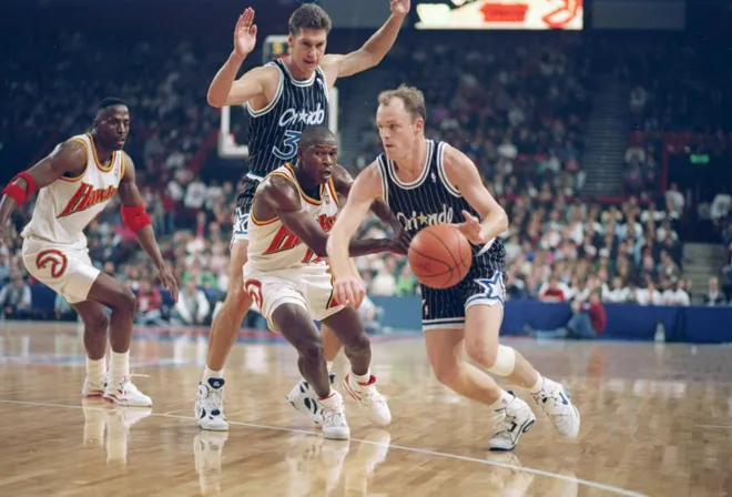 Guard Scott Skiles of the Orlando Magic (right) drives the ball down the court.