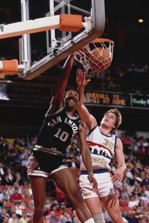 Dave Greenwood dunks the basketball over Mark Alarie of the Denver Nuggets.