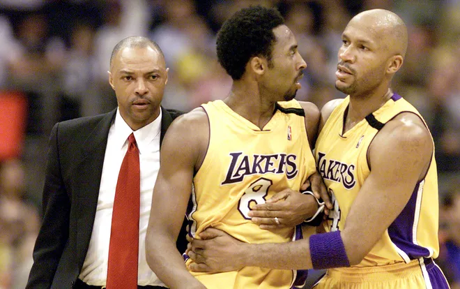 Kobe Bryant is led off the court by teammate Ron Harper (right) and assistant coach Jim Cleamons (left) after an altercation with the New York Knicks' Chris Childs.