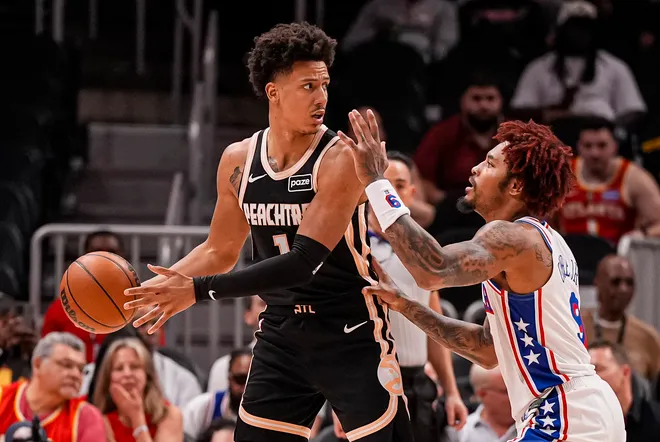 Mar 7, 2026; Atlanta, Georgia, USA; Atlanta Hawks forward Jalen Johnson (1) protects the ball against Philadelphia 76ers forward/guard Kelly Oubre Jr. (9) during the first half at State Farm Arena. Mandatory Credit: Dale Zanine-Imagn Images