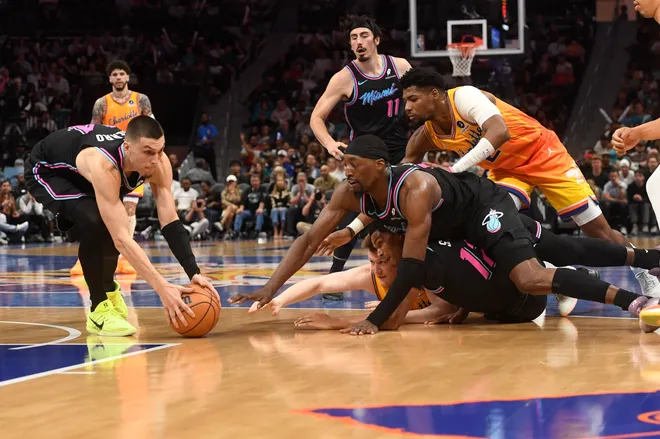 Mar 6, 2026; Charlotte, North Carolina, USA; Miami Heat guard Tyler Herro (14) gets a loose ball from Charlotte Hornets forward Kon Knueppel (7), Miami Heat guard Dru Smith (12) and center forward Bam Adebayo (13) during the second half at the Spectrum Center. Mandatory Credit: Sam Sharpe-Imagn Images.