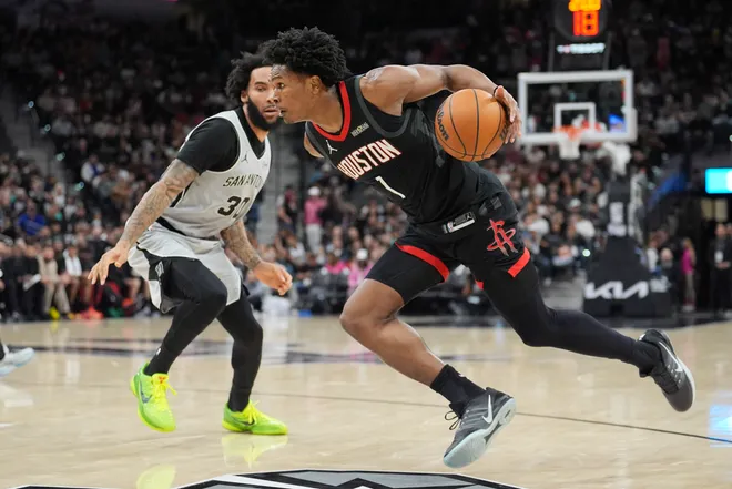 Mar 8, 2026; San Antonio, Texas, USA; Houston Rockets guard Amen Thompson (1) dribbles the in front of San Antonio Spurs forward Julian Champagnie (30) in the first half at Frost Bank Center. Mandatory Credit: Daniel Dunn-Imagn Images