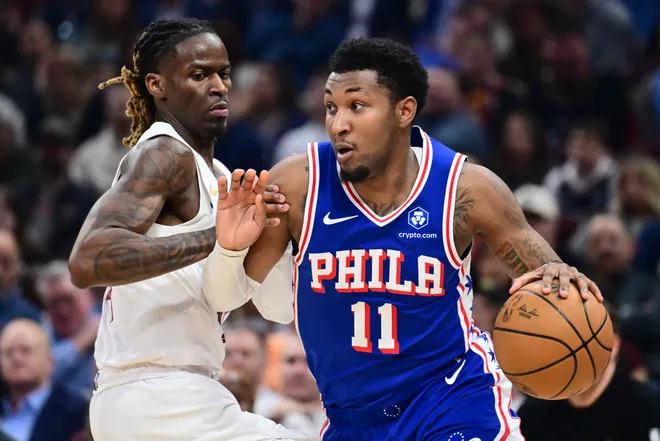 Mar 9, 2026; Cleveland, Ohio, USA; Philadelphia 76ers forward Justin Edwards (11) drives to the basket against Cleveland Cavaliers guard Keon Ellis (14) during the first half at Rocket Arena. Mandatory Credit: Ken Blaze-Imagn Images