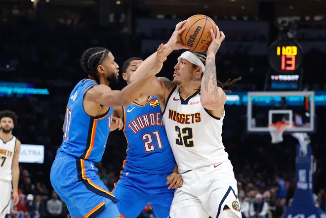 Mar 9, 2026; Oklahoma City, Oklahoma, USA; Denver Nuggets forward Aaron Gordon (32) drives between Oklahoma City Thunder guard Isaiah Joe (11) and guard Aaron Wiggins (21) during the second quarter at Paycom Center. Mandatory Credit: Alonzo Adams-Imagn Images