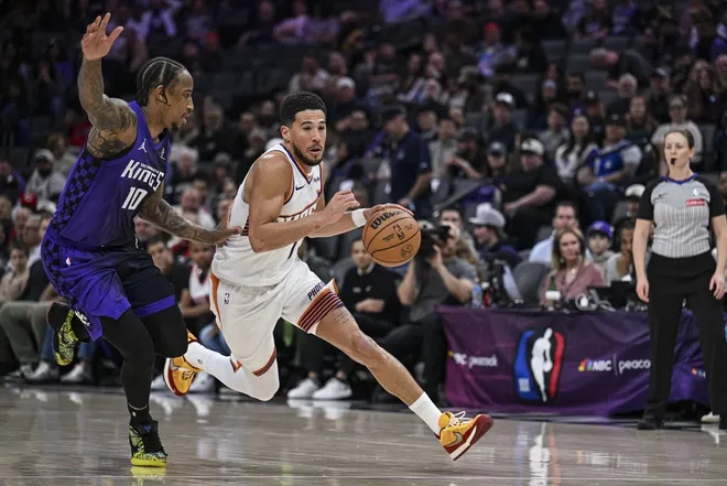 Mar 3, 2026; Sacramento, California, USA; Phoenix Suns guard Devin Booker (1) dribbles past Sacramento Kings guard DeMar DeRozan (10) during the second quarter at Golden 1 Center.