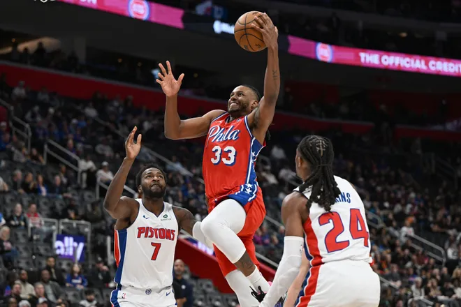 Mar 12, 2026; Detroit, Michigan, USA; Philadelphia 76ers forward Jabari Walker (33) drives to the basket between Detroit Pistons forward Paul Reed (7) and Detroit Pistons guard Daniss Jenkins (24) in the second half at Little Caesars Arena. Mandatory Credit: Lon Horwedel-Imagn Images