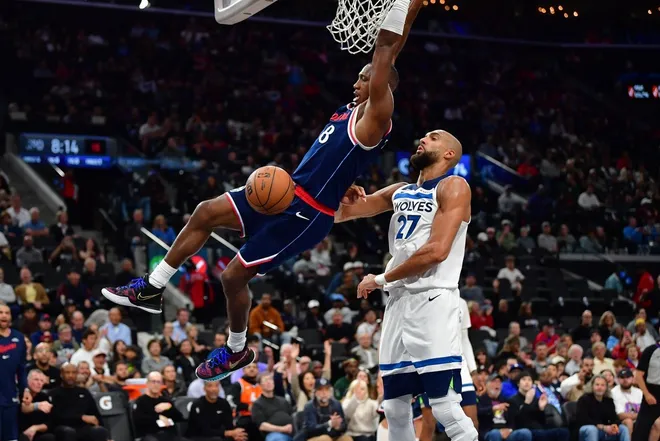 Mar 11, 2026; Inglewood, California, USA; Los Angeles Clippers guard Kris Dunn (8) dunks for the basket in front of Minnesota Timberwolves center Rudy Gobert (27) during the second half at Intuit Dome.
