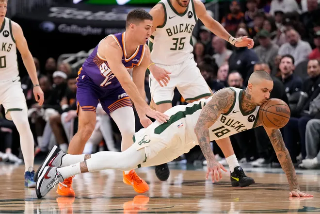 Mar 10, 2026; Milwaukee, Wisconsin, USA; Milwaukee Bucks forward Kyle Kuzma (18) chases the loose ball in front of Phoenix Suns guard Collin Gillespie (12) during the fourth quarter at Fiserv Forum. Mandatory Credit: Jeff Hanisch-Imagn Images