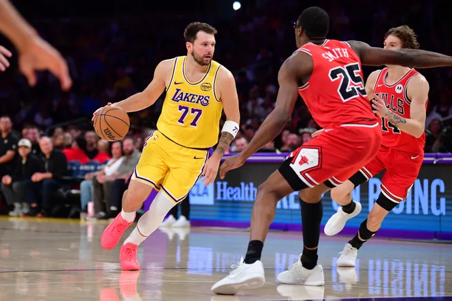 Mar 12, 2026; Los Angeles, California, USA; Los Angeles Lakers guard Luka Doncic (77) moves the ball against Chicago Bulls forward Jalen Smith (25) and forward Matas Buzelis (14)during the first half at Crypto.com Arena. Mandatory Credit: Gary A. Vasquez-Imagn Images