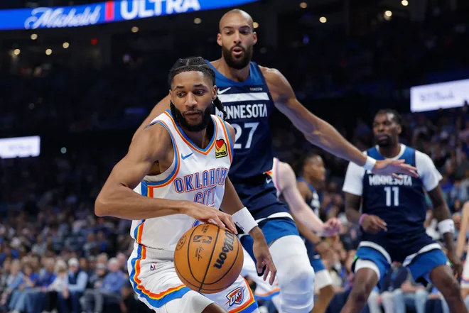 Mar 15, 2026; Oklahoma City, Oklahoma, USA; Oklahoma City Thunder guard Isaiah Joe (11) moves the ball beside Minnesota Timberwolves center Rudy Gobert (27) during the first half at Paycom Center. Mandatory Credit: Alonzo Adams-Imagn Images