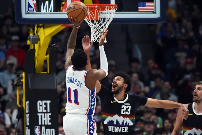 Mar 17, 2026; Denver, Colorado, USA; Philadelphia 76ers forward Justin Edwards (11) shoots as he is defended by Denver Nuggets forward Cameron Johnson (23) during the first half at Ball Arena. Mandatory Credit: Christopher Hanewinckel-Imagn Images