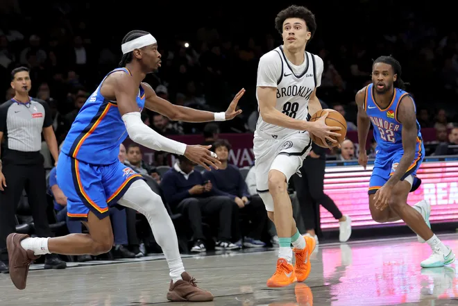 Mar 18, 2026; Brooklyn, New York, USA; Brooklyn Nets guard Nolan Traore (88) drives to the basket against Oklahoma City Thunder guards Shai Gilgeous-Alexander (2) and Cason Wallace (22) during the third quarter at Barclays Center. Mandatory Credit: Brad Penner-Imagn Images