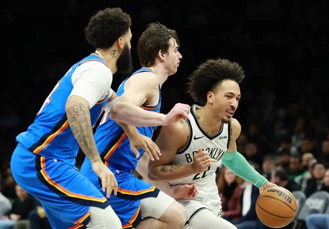 NEW YORK, NEW YORK - MARCH 18: Jalen Wilson #22 of the Brooklyn Nets dribbles against Brooks Barnhizer #23 and Kenrich Williams #34 of the Oklahoma City Thunder during the second half at Barclays Center on March 18, 2026 in the Brooklyn borough of New York City. The Thunder won 121-92. NOTE TO USER: User expressly acknowledges and agrees that, by downloading and or using this photograph, User is consenting to the terms and conditions of the Getty Images License Agreement. (Photo by Sarah Stier/Getty Images)