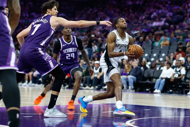 Mar 17, 2026; Sacramento, California, USA; San Antonio Spurs guard De'aaron Fox (4) drives to the basket past Sacramento Kings guard Daeqwon Plowden (29) during the second quarter at Golden 1 Center.