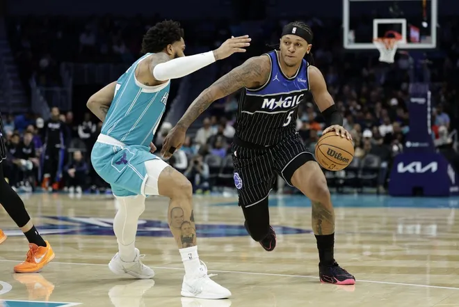 Mar 19, 2026; Charlotte, North Carolina, USA; Orlando Magic forward Paolo Banchero (5) drives past Charlotte Hornets forward Miles Bridges (0) during the third quarter at Spectrum Center.