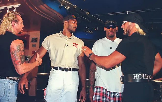 Professional basketball great Karl Malone (2nd L) is restrained by wrestling partner Diamond Dallas Page (L) as World Champion Professional wrestler Hollywood Hulk Hogan (R) pushes the Utah Jazz player following a press conference that also included NBA great Dennis Rodman.