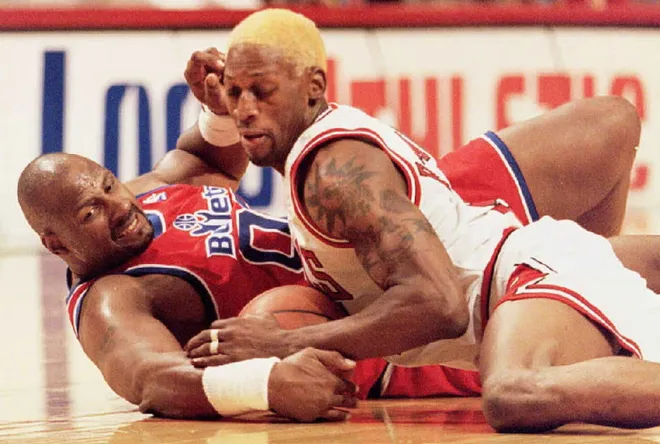 Chicago Bulls forward Dennis Rodman wrestles for the ball with Washington Bullets center Kevin Duckworth.