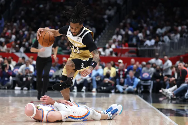 WASHINGTON, DC - MARCH 21: Sharife Cooper #13 of the Washington Wizards falls over Alex Caruso #9 of the Oklahoma City Thunder during the second half at Capital One Arena on March 21, 2026 in Washington, DC. NOTE TO USER: User expressly acknowledges and agrees that, by downloading and or using this photograph, User is consenting to the terms and conditions of the Getty Images License Agreement. (Photo by Patrick Smith/Getty Images)